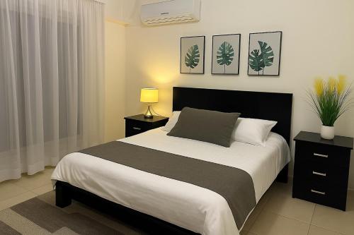 a bedroom with a large bed with a black headboard at Property Sisters Madinaty, Elite garden view B2 in Madinaty