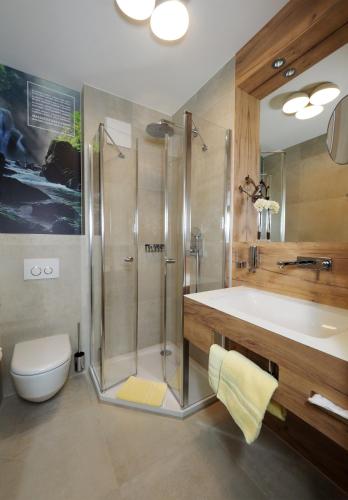 a bathroom with a shower and a sink and a toilet at Hotel Lindenhof in Kellberg