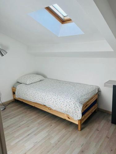 - un lit dans une chambre dotée d'une lucarne dans l'établissement Bordeaux Centre T2 Duplex 65m Hospital Pellegrin CHU, à Mérignac