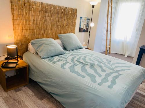 une chambre avec un grand lit avec une tête de lit en bois dans l'établissement Votre appt en plein coeur du Touquet, à Le Touquet-Paris-Plage