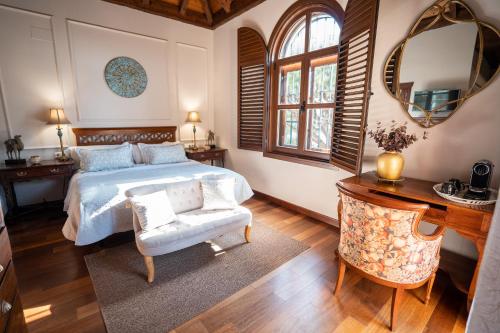 a bedroom with a bed and a chair and a mirror at Hotel Azalea Playa in Chiclana de la Frontera
