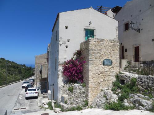 a building on the side of a road with purple flowers at Case Vacanza Al Borgo Antico in Vico del Gargano