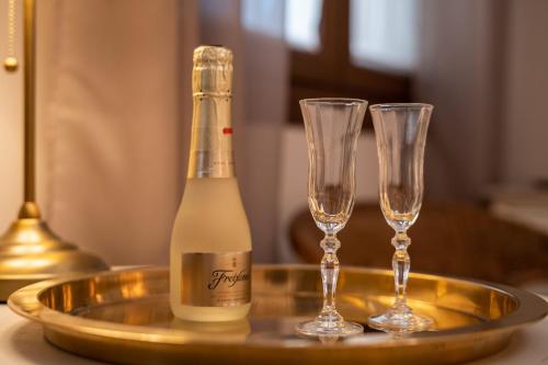 a bottle of champagne and two wine glasses on a tray at Hotel Azalea Playa in Chiclana de la Frontera