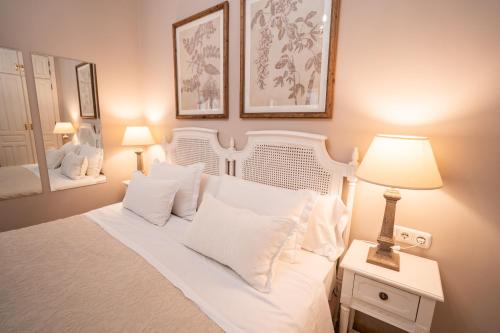 a bedroom with a white bed with white pillows at Hotel Azalea Playa in Chiclana de la Frontera