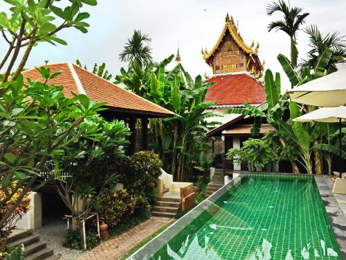 eine Villa mit einem Swimmingpool vor einem Haus in der Unterkunft Baan Saen Fang Chiang Mai in Chiang Mai