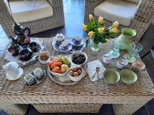 a table with bowls of fruit and other dishes on it at Cascina Petricore - Elegante dimora tra le colline del Monferrato in Moncalvo