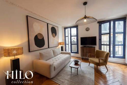 un salon avec un canapé et une télévision dans l'établissement HILO Suite Paris Zola - 4pers - 35m2, à Paris