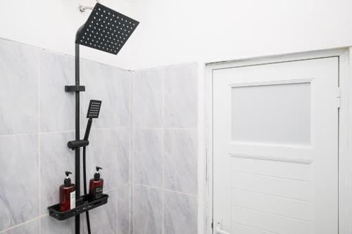 a bathroom with a shower with a white door at RedDoorz near Candi Prambanan 3 Yogyakarta in Kenaran