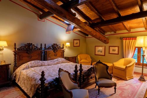 a bedroom with a bed and chairs in a room at Locanda San Vigilio in Garda