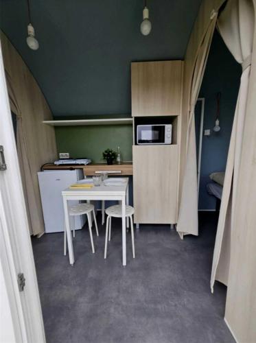 une petite cuisine avec une table et des chaises blanches dans l'établissement Camping - Piscine - ccb0cfa, à Angles