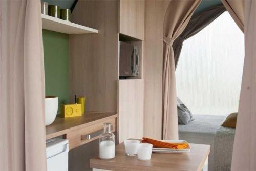 d'une cuisine avec un comptoir, un évier et une fenêtre. dans l'établissement Chalet 4 étoiles - Piscine - ef0c00, à Monceaux-sur-Dordogne