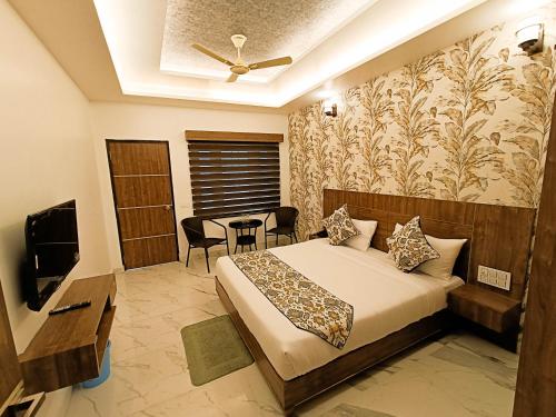 a bedroom with a bed and a table and a television at Hotel Cloud Inn, Nainital in Rāmgarh