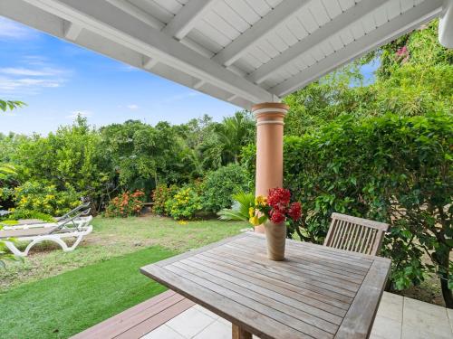 a wooden table with a vase of flowers on a porch at Archipel View Villa in Grand Case