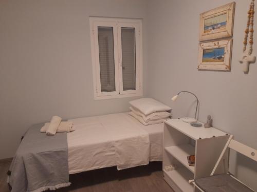 a small bedroom with a bed and a window at The Blue Door in Lixouri