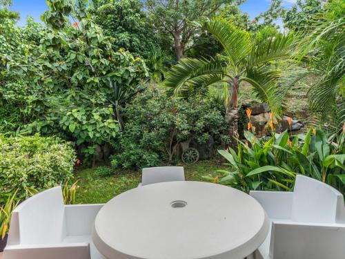 a white table and chairs in a garden at Archipel View Villa in Grand Case
