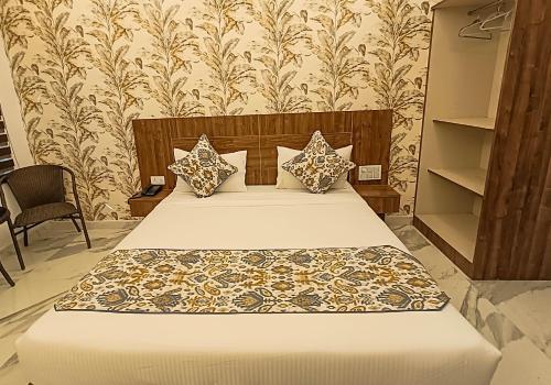a bedroom with a bed and a wall with wallpaper at Hotel Cloud Inn, Nainital in Rāmgarh
