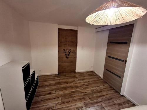 a room with a hallway with wooden floors and a chandelier at Le 421, Maison d'hôtes Jacuzzi entre amis,familles in Béziers