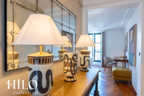 deux lampes posées sur une table dans un salon dans l'établissement HILO Suite Paris Stendhal - 6pers - 70m2, à Paris