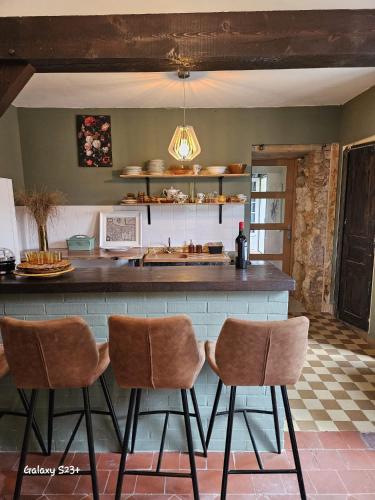 - une cuisine avec un bar avec deux tabourets dans l'établissement Le Moulin en Route kamer rose en grijs, badkamer en suite, à Blèves