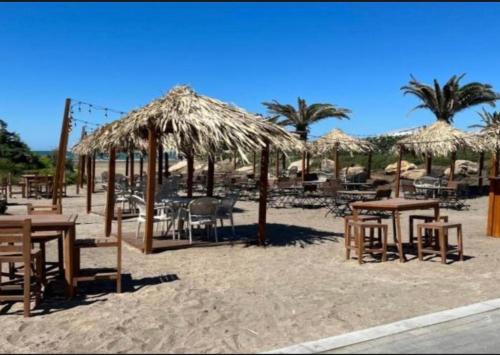 a beach with tables and chairs and straw umbrellas at Baku, SEA BREEZE on the shores of the Caspian Sea in Bilgah
