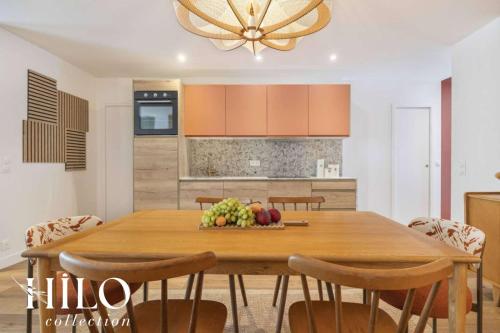 une table de salle à manger avec un bol de fruits dessus dans l'établissement HILO Suite Paris Balzac - 6 pers - 63m2, à Paris