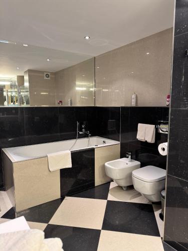 a bathroom with a tub and a toilet and a sink at Magic View Apartman Vyhlidka in Karlovy Vary