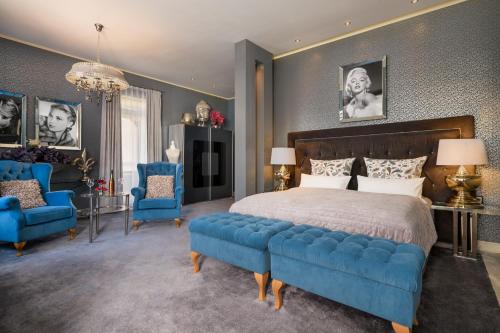 a bedroom with a large bed and blue chairs at Hotel Luise in Bad Bergzabern