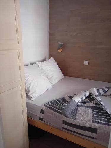 - un lit avec des oreillers blancs et une couverture dans l'établissement Appartement T2 avec piscine a 100 m de la plage, à Six-Fours-les-Plages