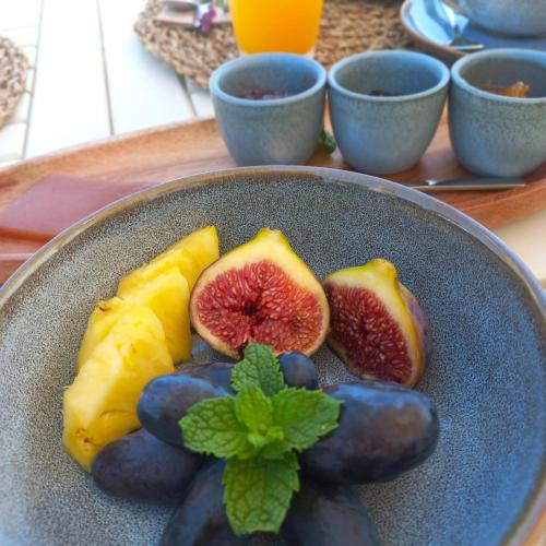 a plate of fruit with figs on a table at Villa Lobos Tavira in Tavira