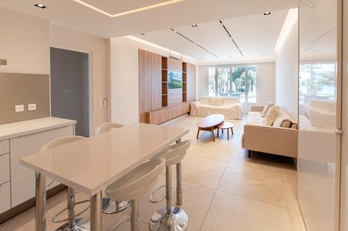 une cuisine et un salon avec une table et des chaises dans l'établissement Élégant T3 - Vue Mer - Croisette Cannes, à Cannes