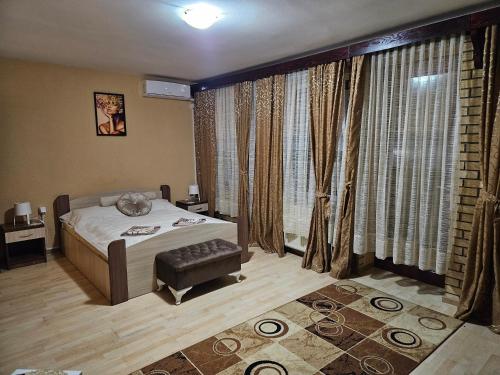 a bedroom with a bed and a large window at Motel RUDNIK 2 in Donja Šatornja