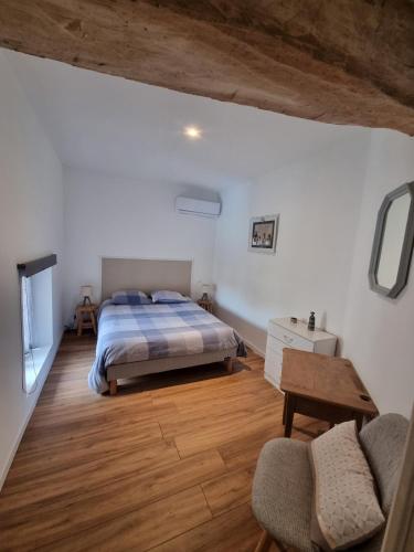 une chambre avec un lit, une table et une chaise dans l'établissement Gîte de Larina, à Hières-sur-Amby