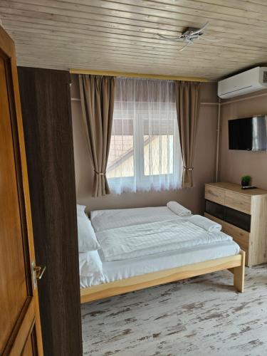 a bedroom with a large bed with a window at Villa Szófia in Siófok