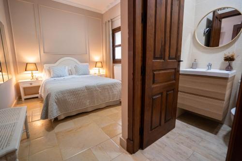 a bedroom with a bed and a sink and a mirror at Hotel Azalea Playa in Chiclana de la Frontera