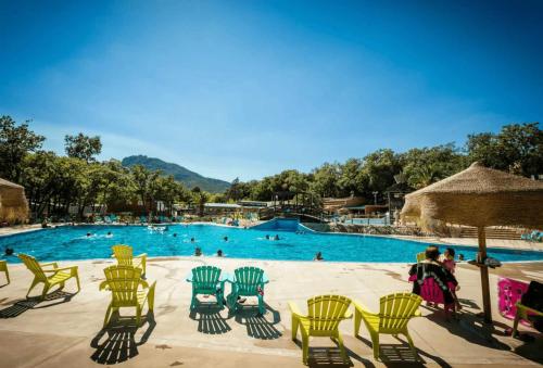 - une piscine avec des chaises jaunes dans l'établissement Camping - Piscine - ccai0bg, à Argelès-sur-Mer