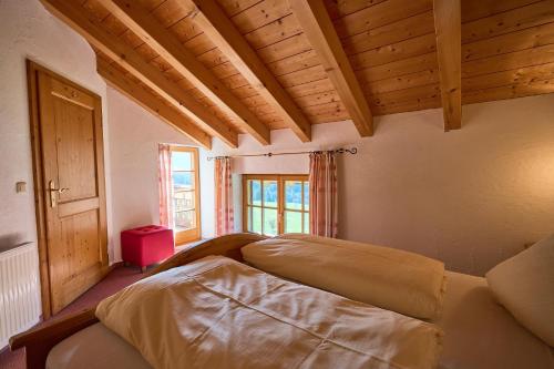 a bedroom with two beds in a room with wooden ceilings at Ferienhof Almfrieden in Balderschwang