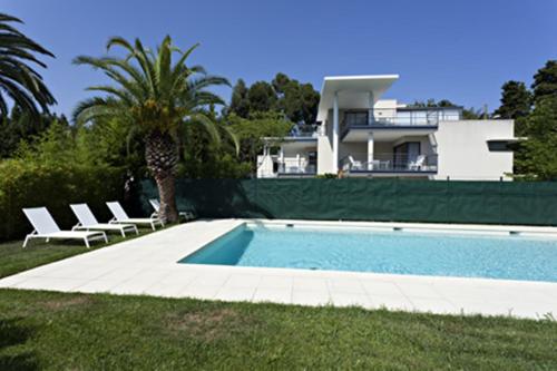a house with a swimming pool in front of a house at Arthur Properties - Montfleury in Cannes