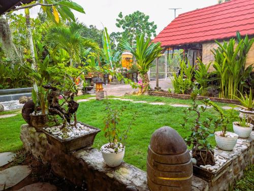 a garden with potted plants on a stone wall at Ayumar Homestay Medewi in Pulukan