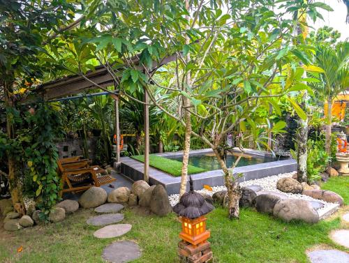 a garden with a table and a lantern in the grass at Ayumar Homestay Medewi in Pulukan