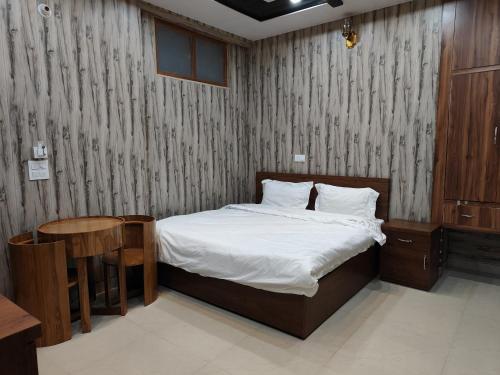 a bedroom with a bed and a table and a bed sidx sidx sidx at Agyatvaas in Bhīm Tāl