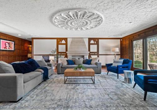 a living room with couches and a chandelier at Unique Estate 5 Bedrooms Fire Pit Sleeps 10 in Akron