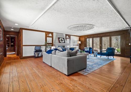 a living room with a gray couch and blue chairs at Unique Estate 5 Bedrooms Fire Pit Sleeps 10 in Akron