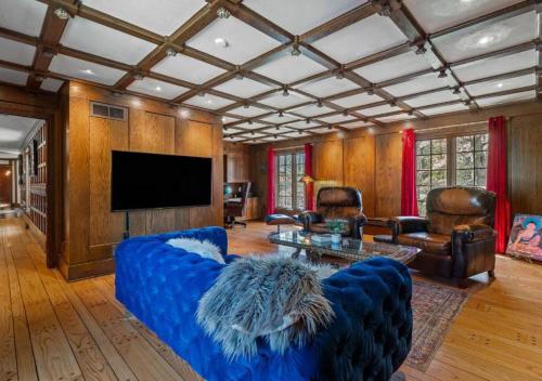 a living room with a blue couch and a tv at Unique Estate 5 Bedrooms Fire Pit Sleeps 10 in Akron