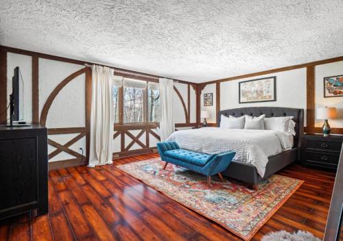 a bedroom with a bed and a blue chair at Unique Estate 5 Bedrooms Fire Pit Sleeps 10 in Akron