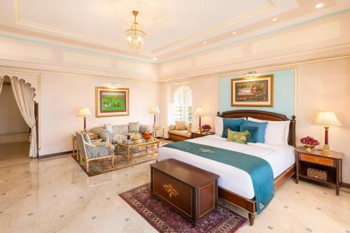 a bedroom with a large bed and a living room at Taj Fateh Prakash Palace Udaipur in Udaipur