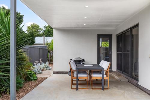 a patio with a black table and chairs at Getaway on Wallace - Fantastic central location in Mount Gambier