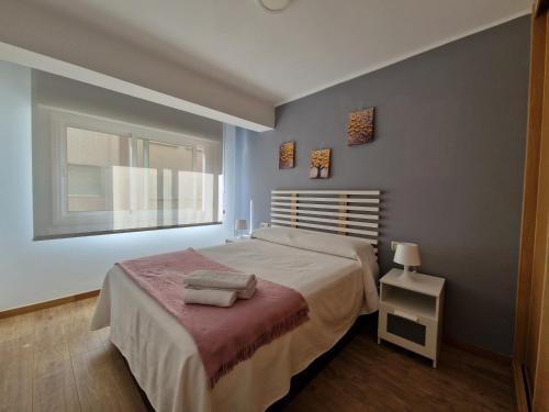 a bedroom with a large bed and a window at Apartamento Playa Bouzas - Vigo - Parking free in Vigo