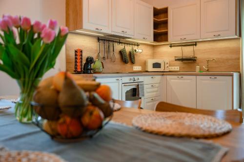 a kitchen with a table with a vase of flowers at Dom pri jazere, Bešeňová in Bešeňová