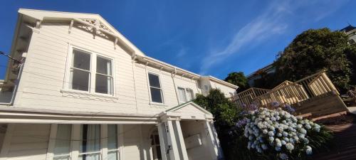 a white house with a bunch of flowers at Newtown Camp de Luxe in Wellington