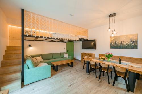 a living room and dining room with a loft bed at Dom pri jazere, Bešeňová in Bešeňová